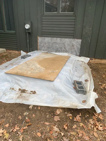 plywood on top of tarp covering cellar door entrance